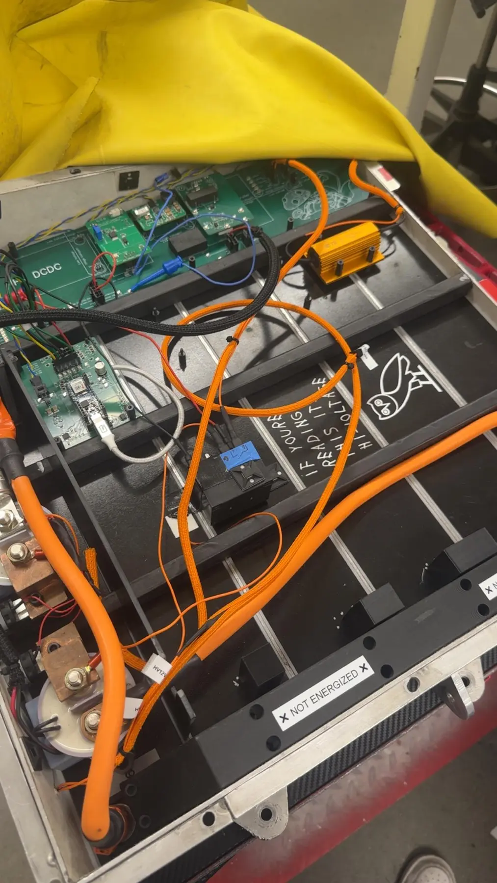 Installed accumulator controls and high-voltage wiring above the battery segments