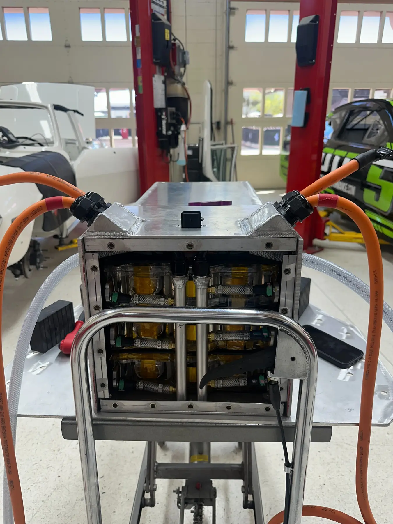 Tesla battery modules assembled inside an aluminum enclosure on a build stand